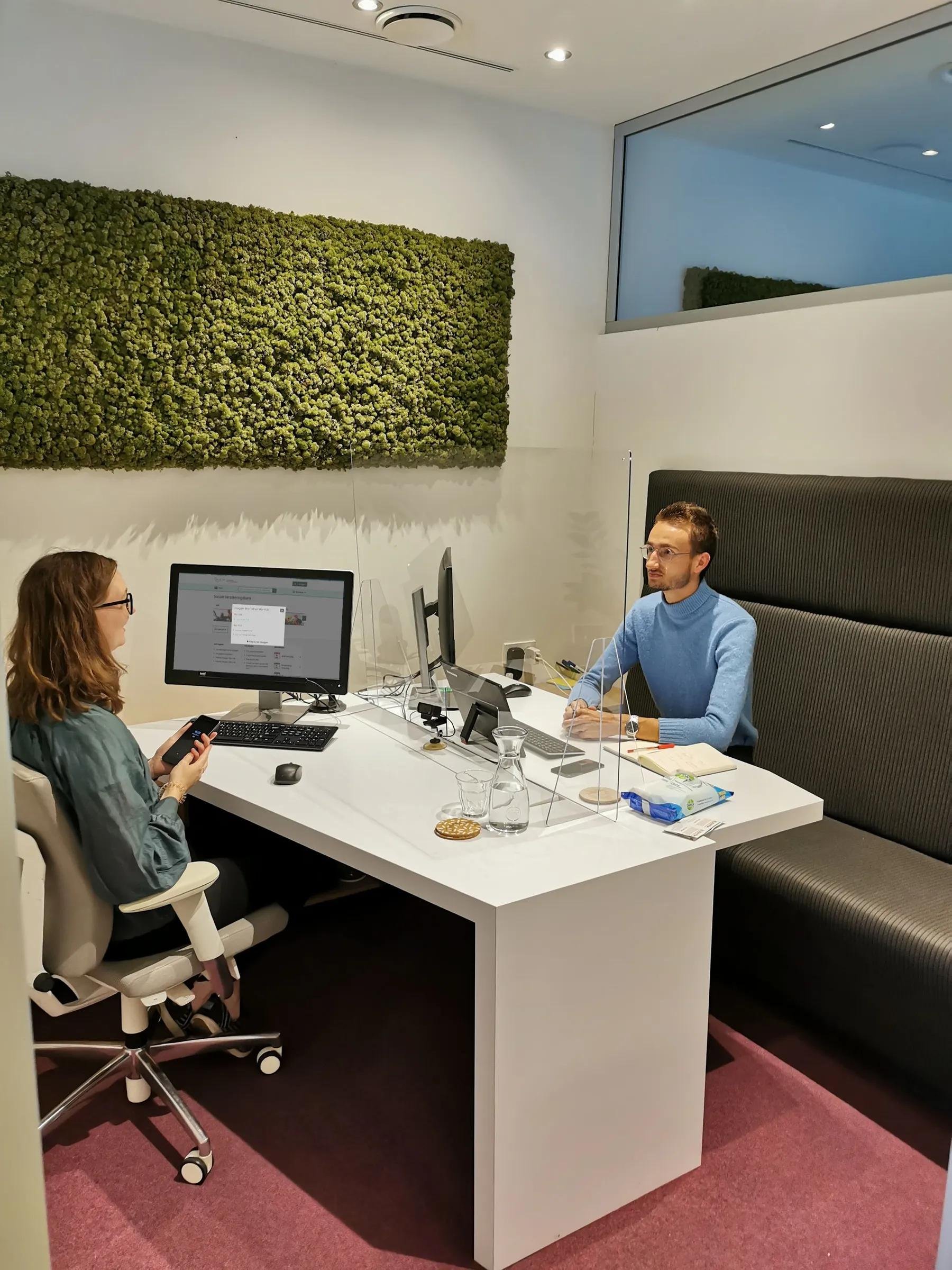 Two people facing each other at a desk.