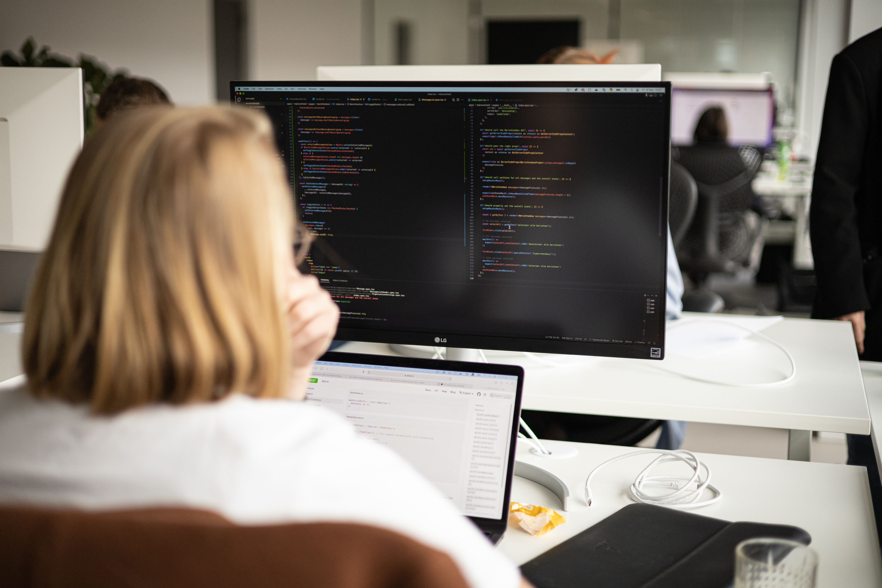 Developer aan het werk achter een beeldscherm met code